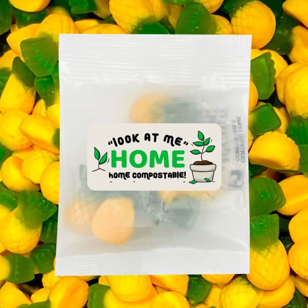A transparent bag contains yellow and green gummi pineapple lollies, with a logo on the packaging.