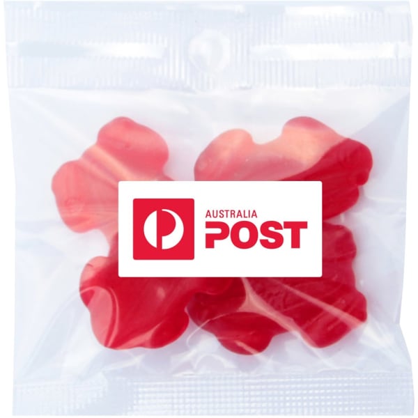 A clear bag containing red gummi lollies shaped like frogs. The bag has a logo.