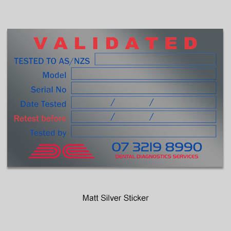 A matt silver sticker featuring a logo, with fields for model, serial number, and testing details.