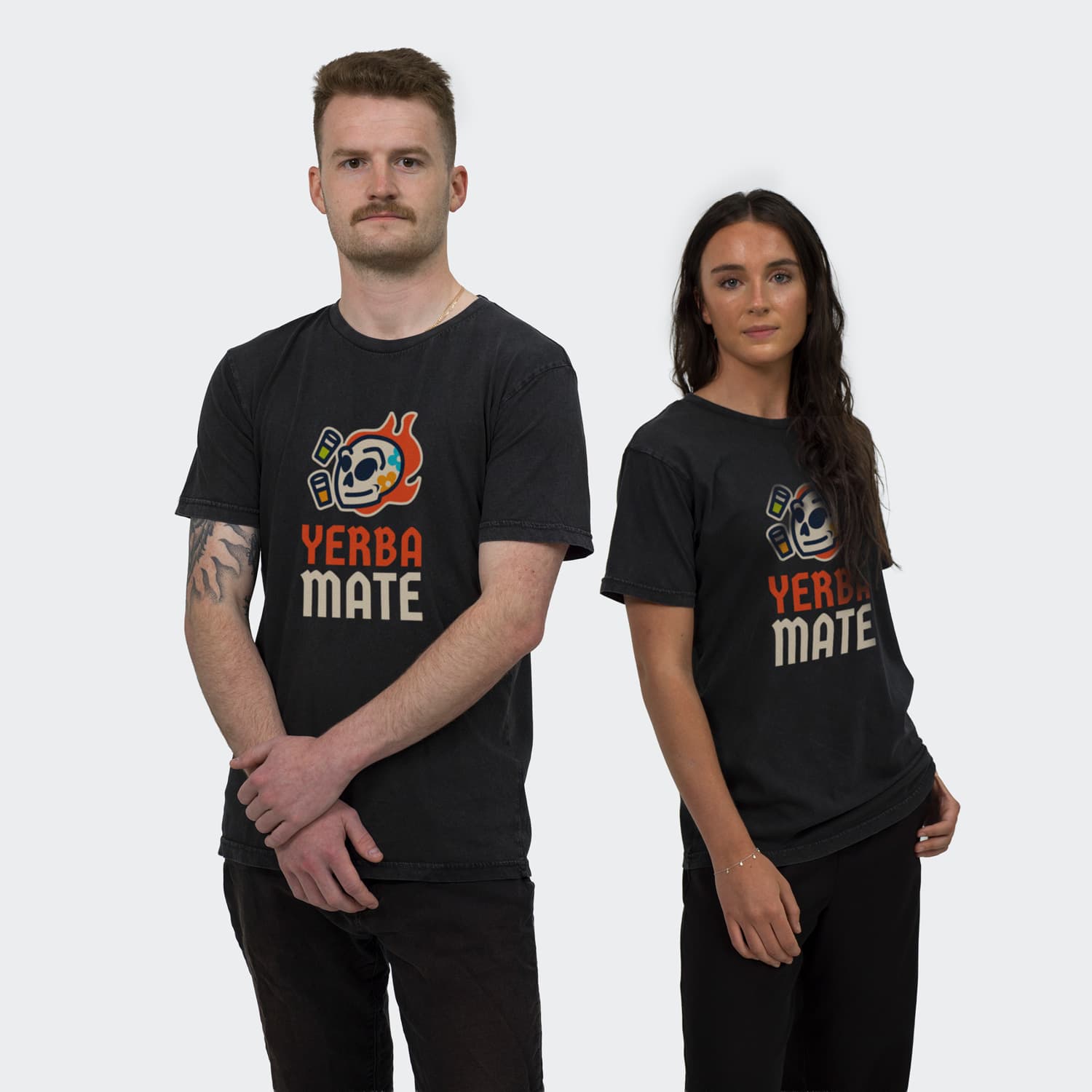 A faded black unisex T-shirt featuring a graphic design with the words "Yerba Mate," worn by a male and female model.