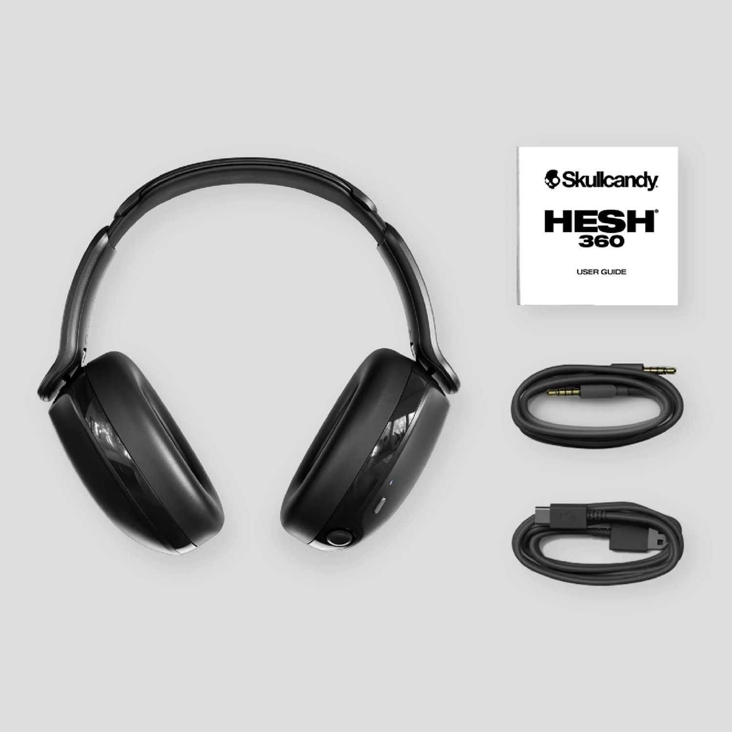 Black Skullcandy Hesh 360 headphones with a USB charging cable and audio cable, along with a user guide.