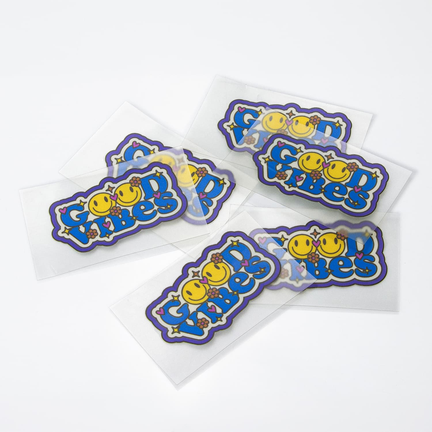 Colourful stickers featuring smiling faces and playful text, with a glossy finish, presented on a white background.
