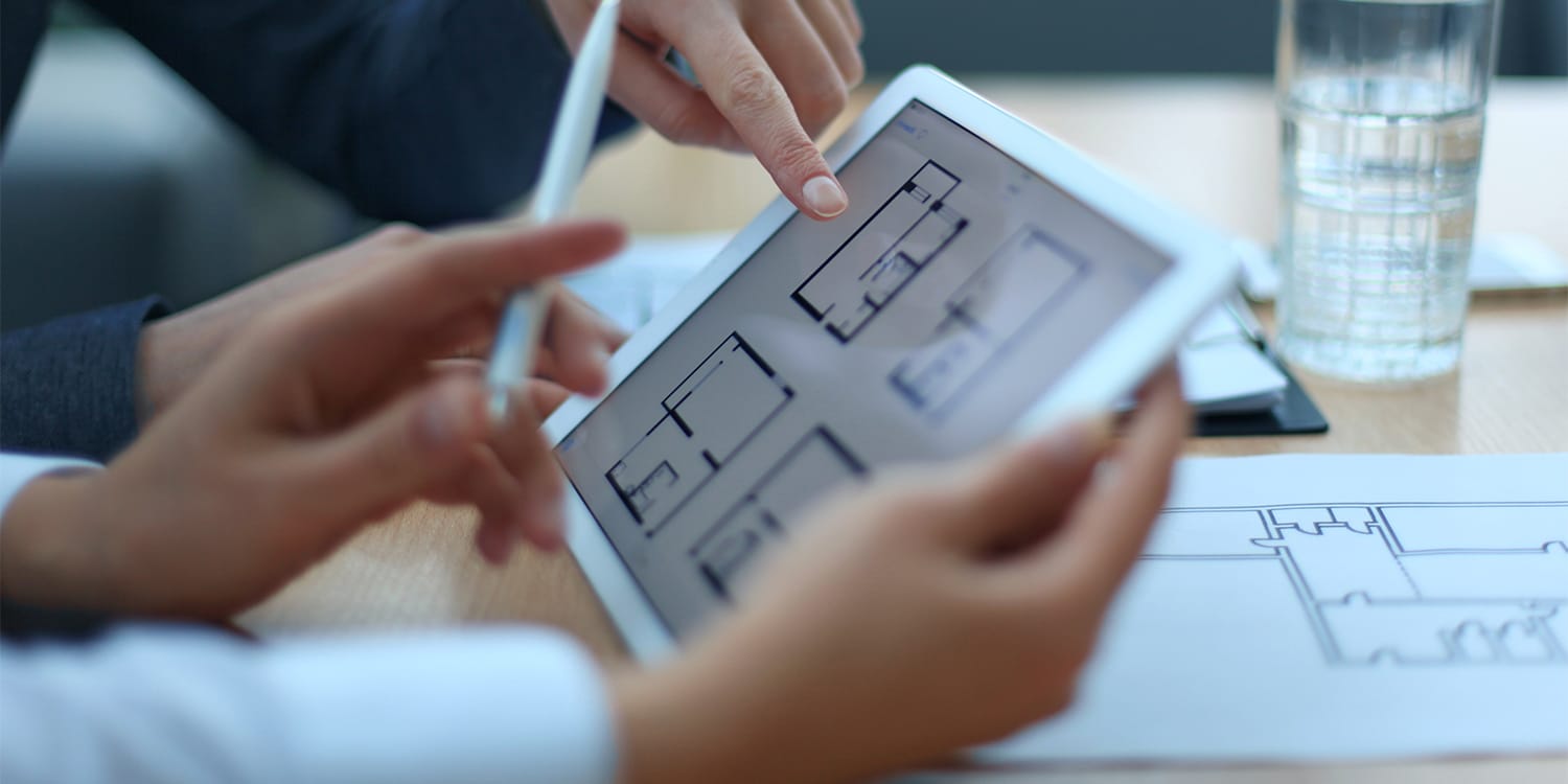 Property manager and landlord reviewing floor plans
