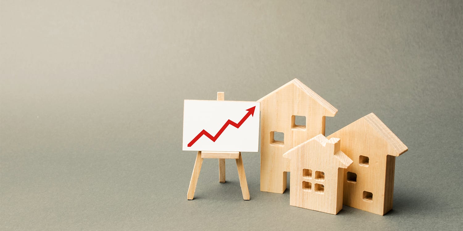 Wooden houses and chart to illustrate increased home selling price
