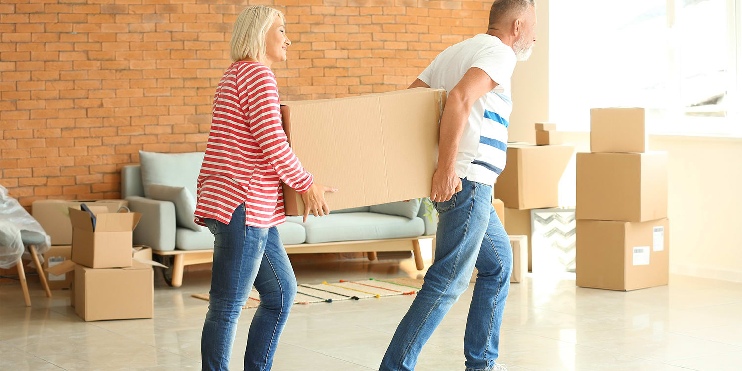 Older couple packing boxes and selling home