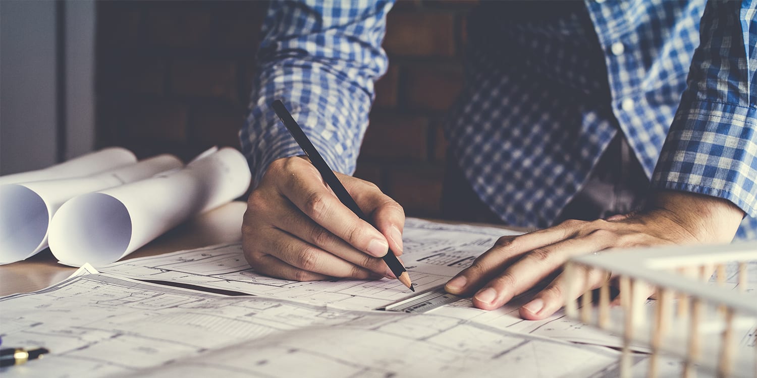 Man with blueprints - renovation budgeting concept
