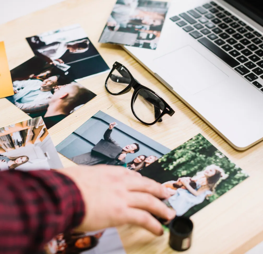 imagen de escritorio con fotos, gafas y una laptop