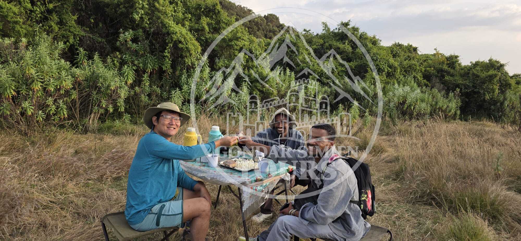 Reisende beim gemeinsamen Essen im Freien im Chenek-Camp