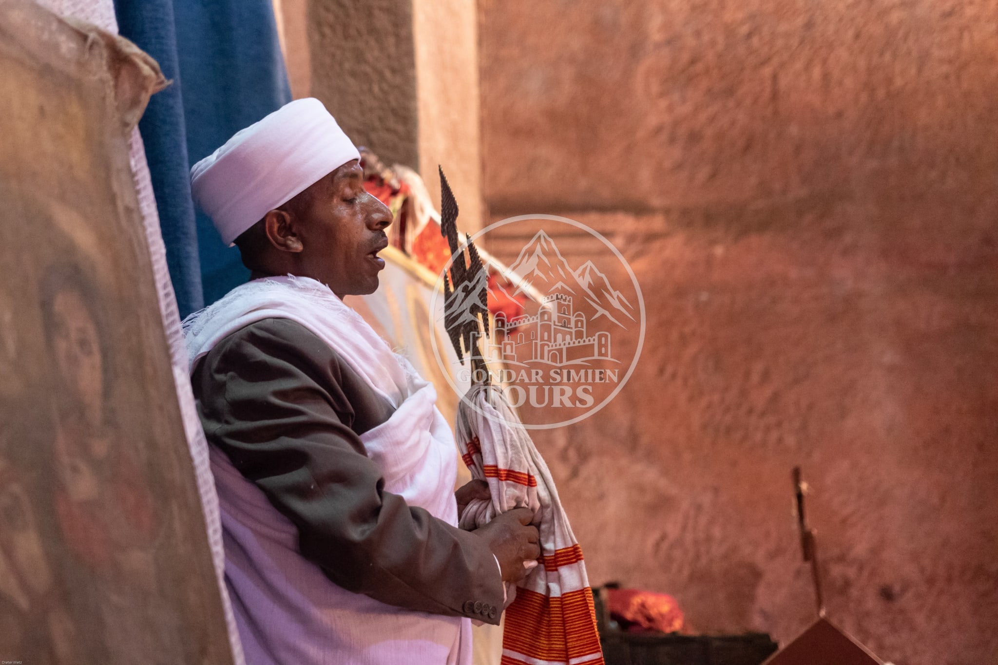 Una persona con vestimenta ceremonial blanca dentro de una iglesia excavada en la roca en Lalibela