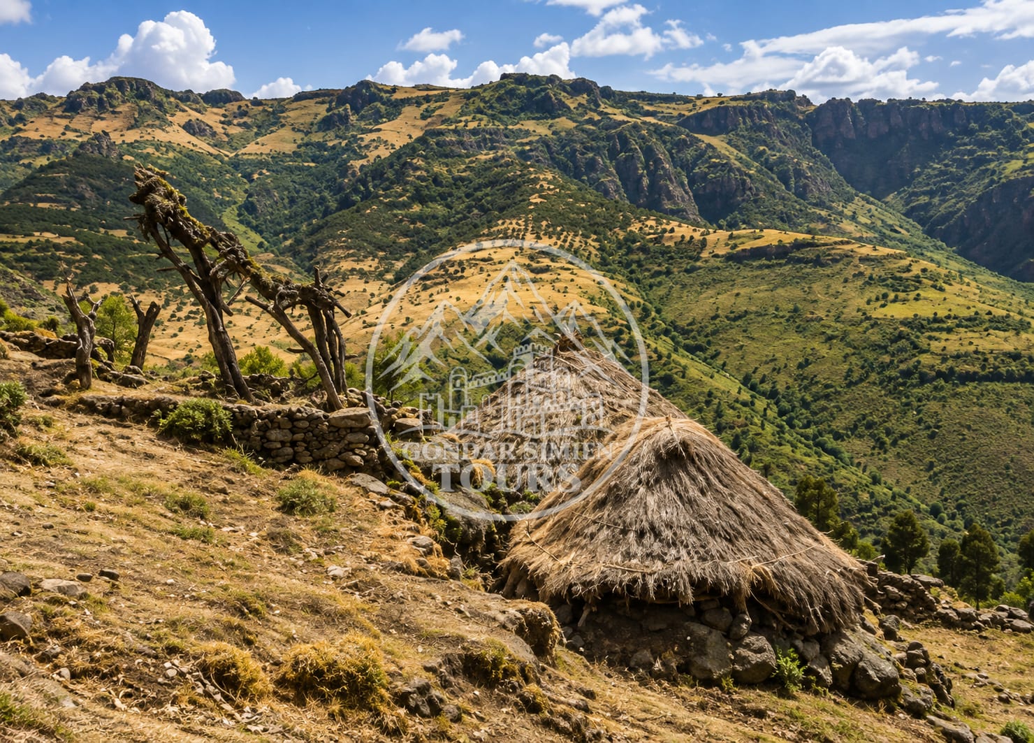 Una cabaña de piedra con techo de paja en una ladera cerca de Ambiko