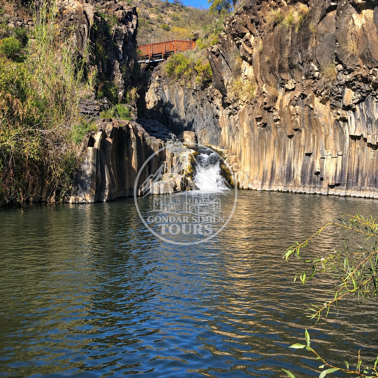 A pool and waterfall between rock walls in the Meseha River landscape