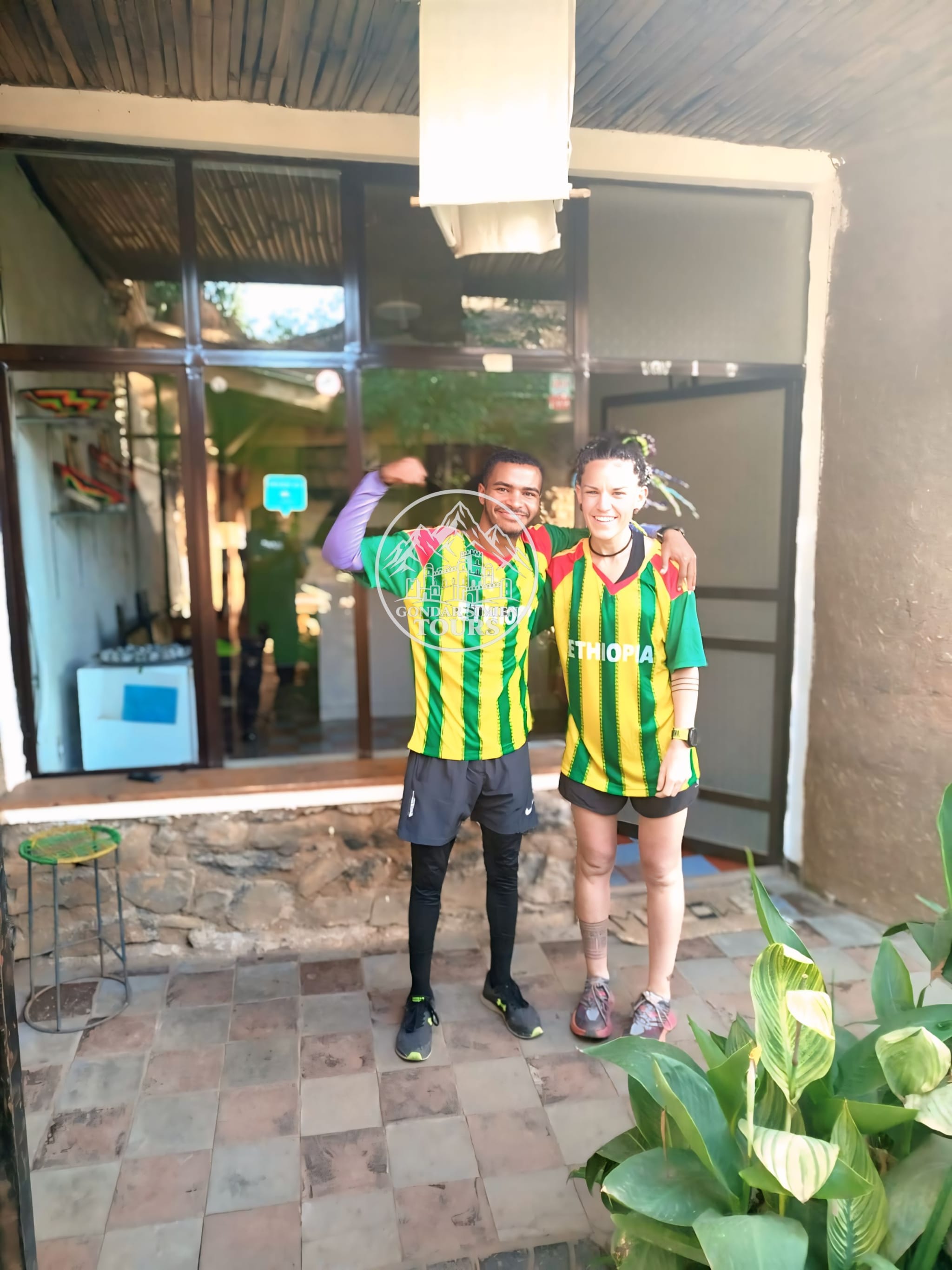 Travellers standing together in matching green and yellow shirts