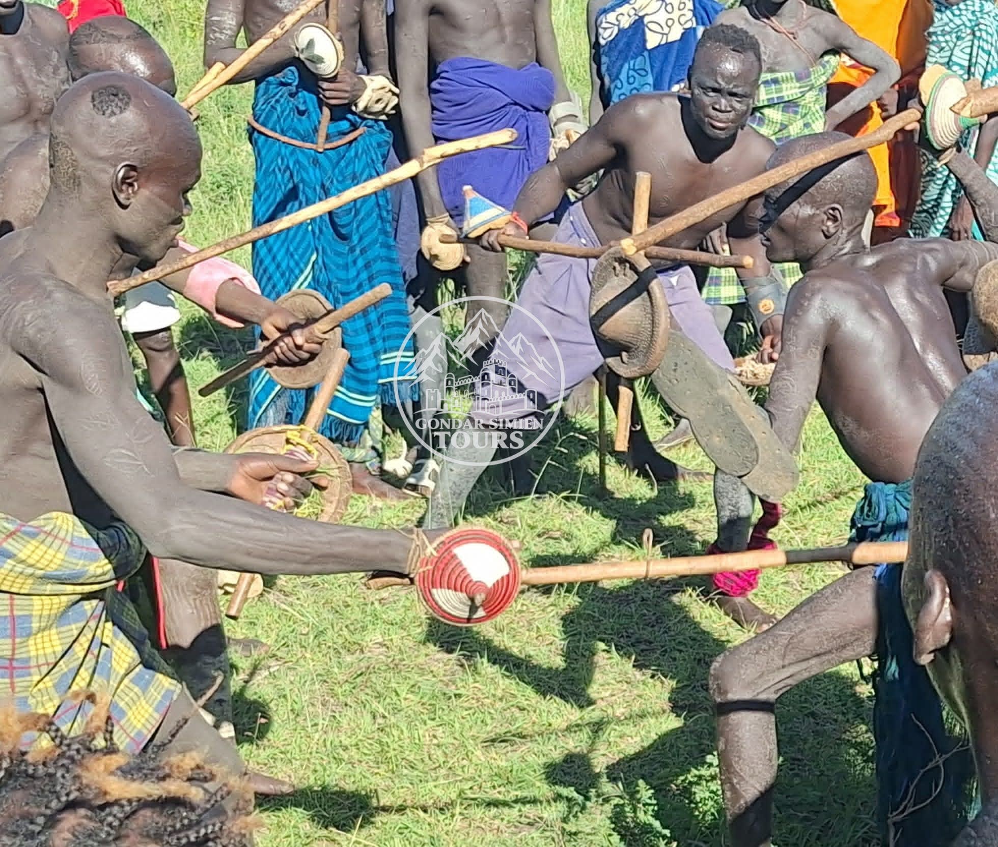 Participants gathered in a circle holding long wooden sticks