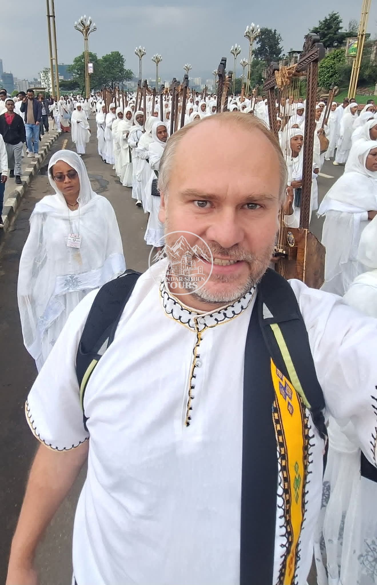 A visitor wearing a white scarf among people dressed in white