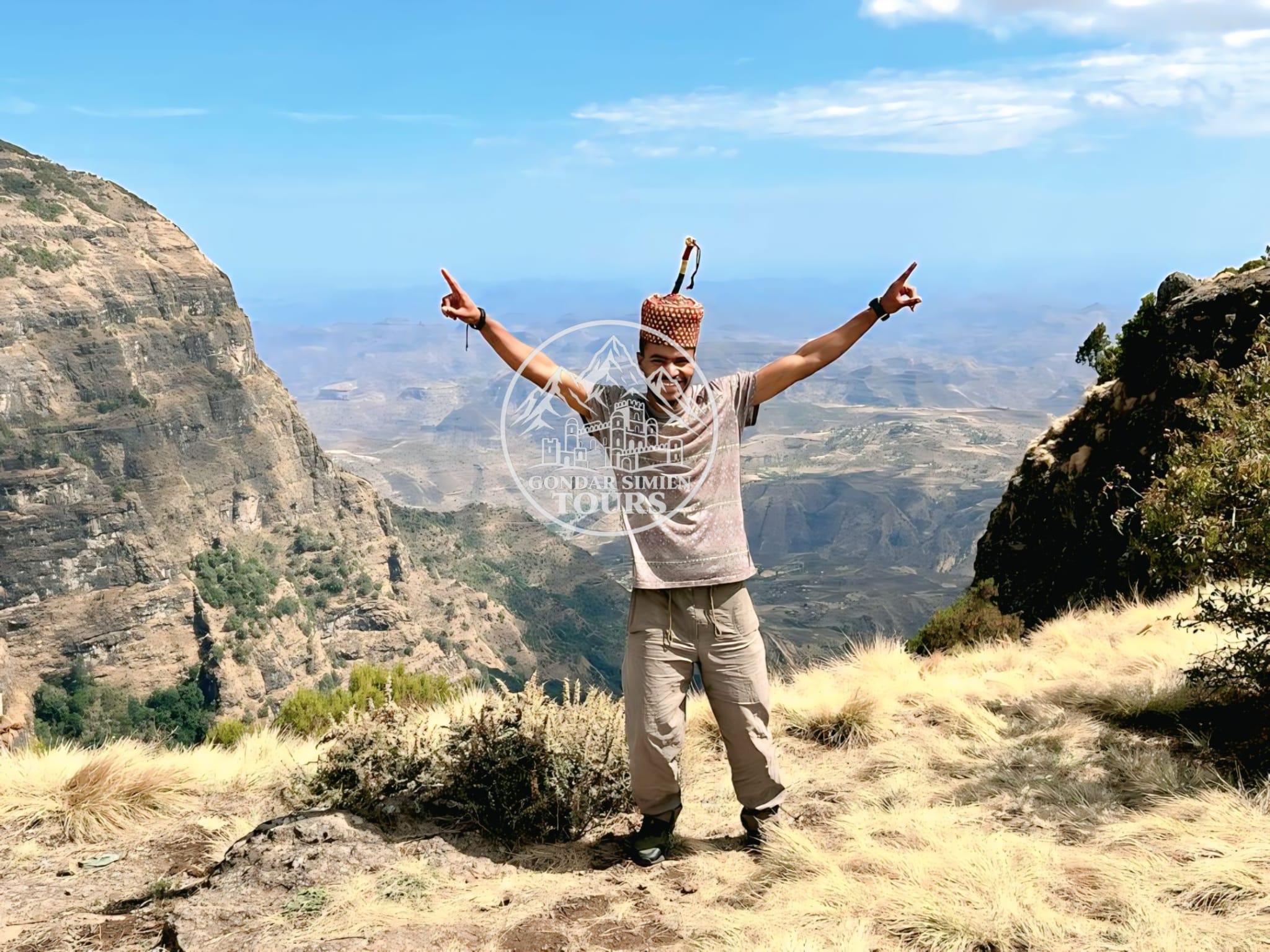 A traveller looking out over mountain ridges and a deep valley