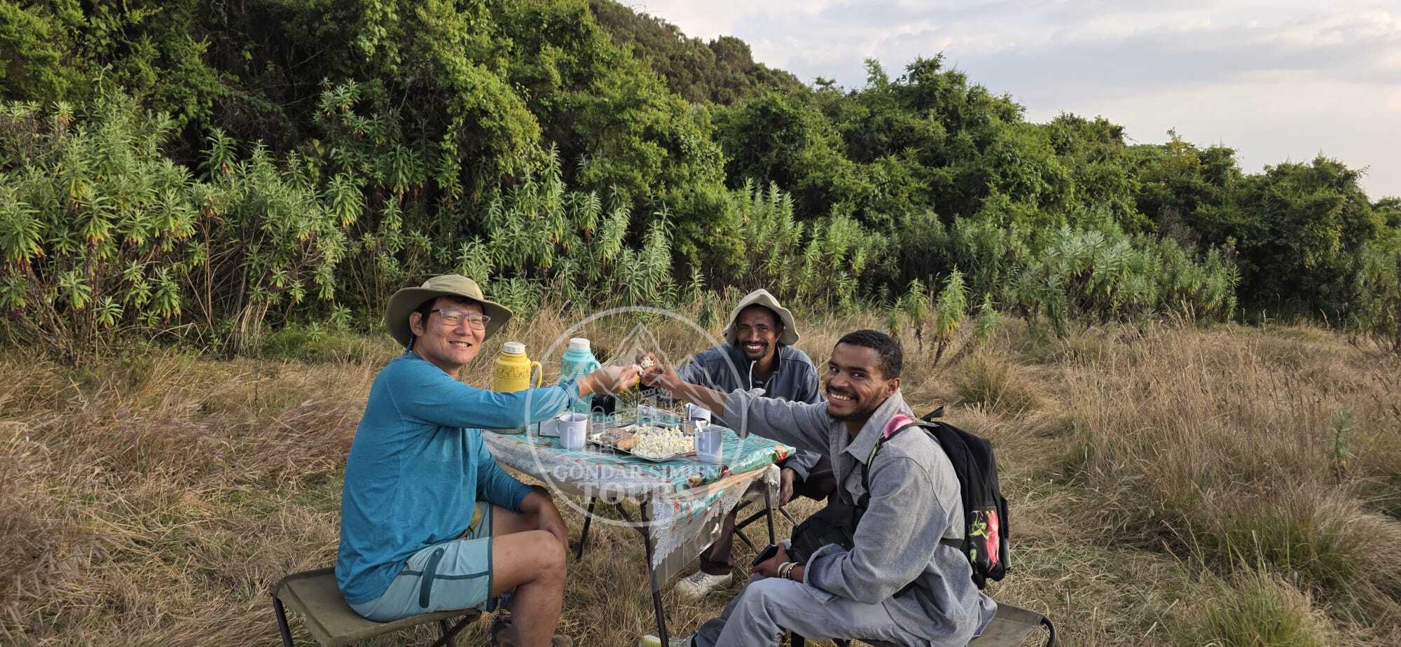 Travellers sharing an outdoor meal at Chenek camp