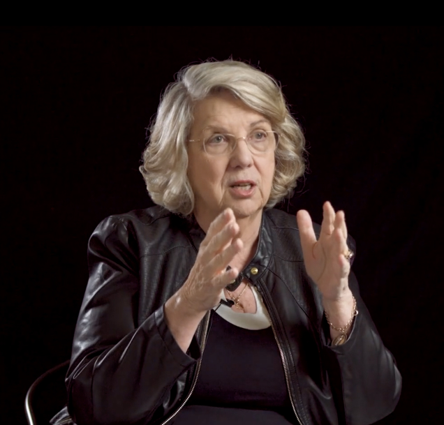 Marsha Linehan with her hands raised mid-explanation.