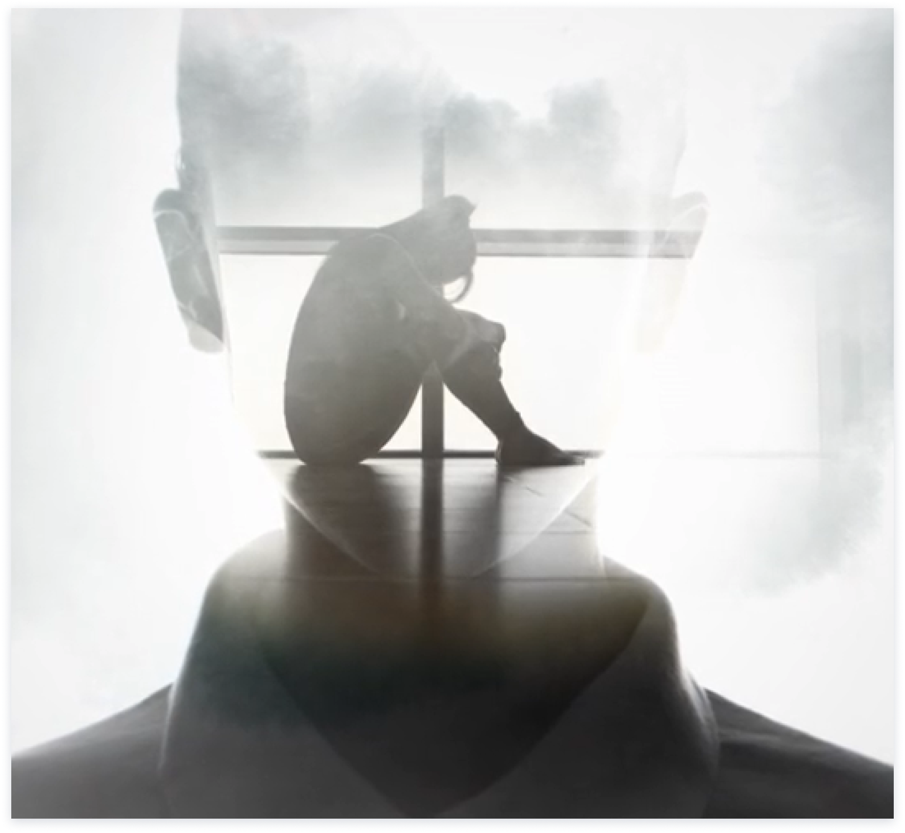 double exposure image of a head and a person sitting hugging their knees