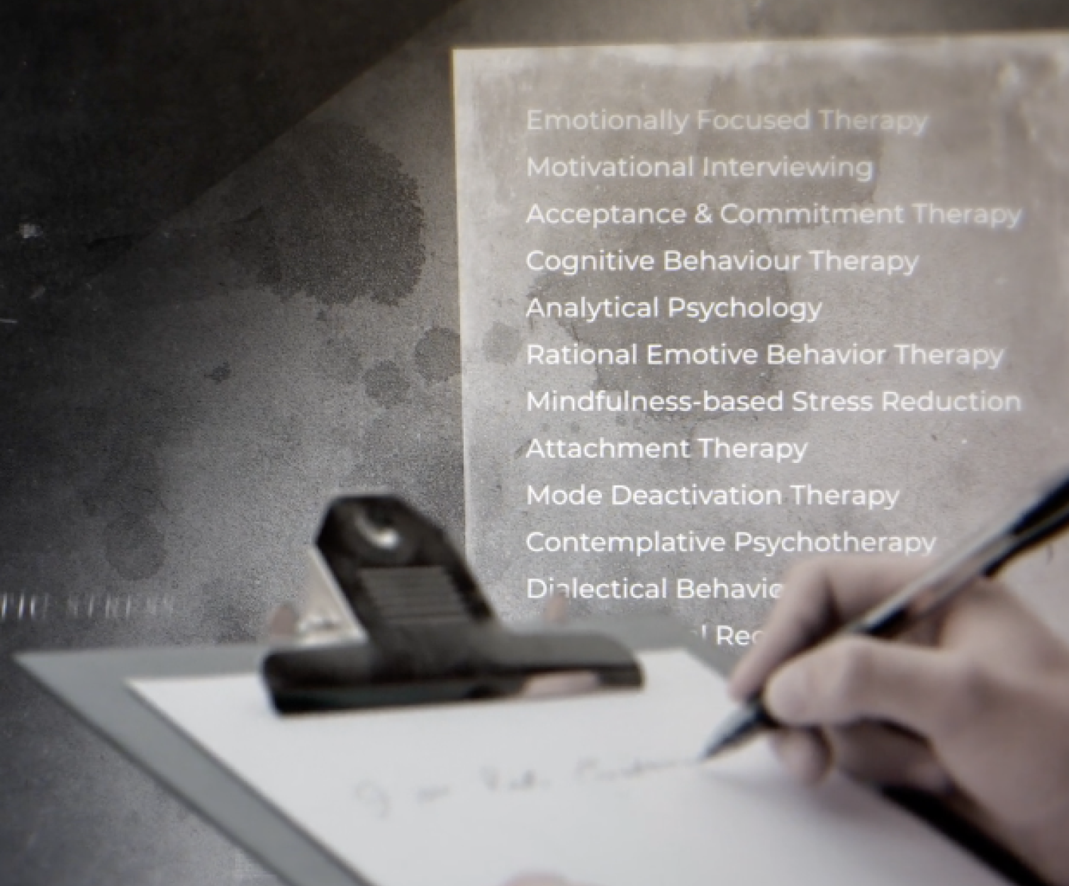 hand holding a pencil at a clipboard with a list in the background