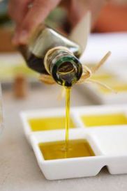 olive oil being poured into a tasting dish with other types of olive oil