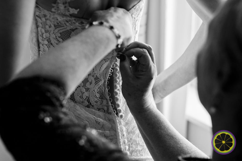 Bride having her gown buttoned