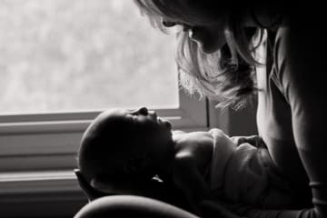 Mother gazing into baby's eyes, with caption "honor motherhood in the season where your feet fall now."