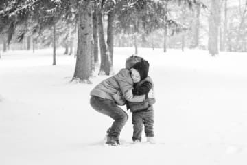 young brothers embrace in the snow in Missouri