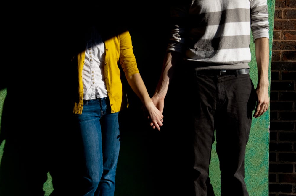 engaged couple holding hands on Delmar Loop in University City for colorful photo with shadows