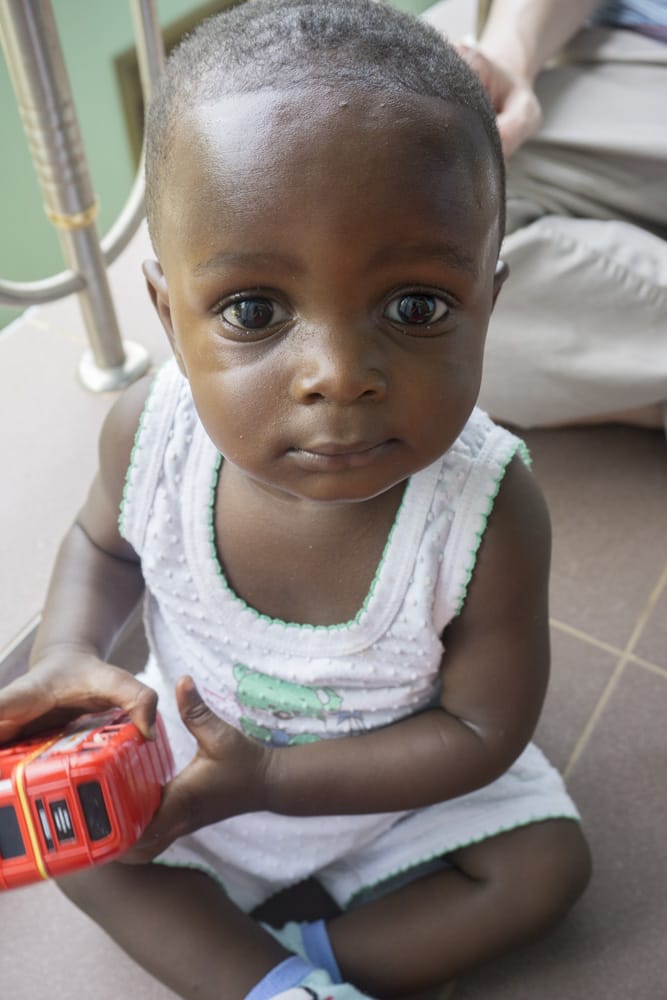 adopted boy holding a new toy in Ghana with family from St. Louis MO