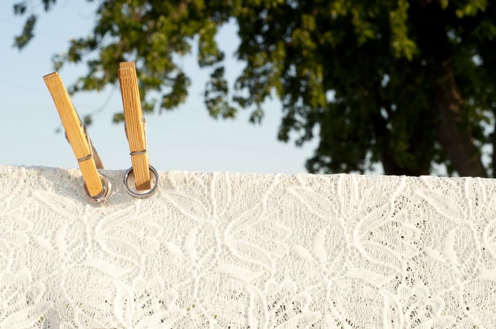 Wedding rings clothespinned on clothesine with lace in Illinois