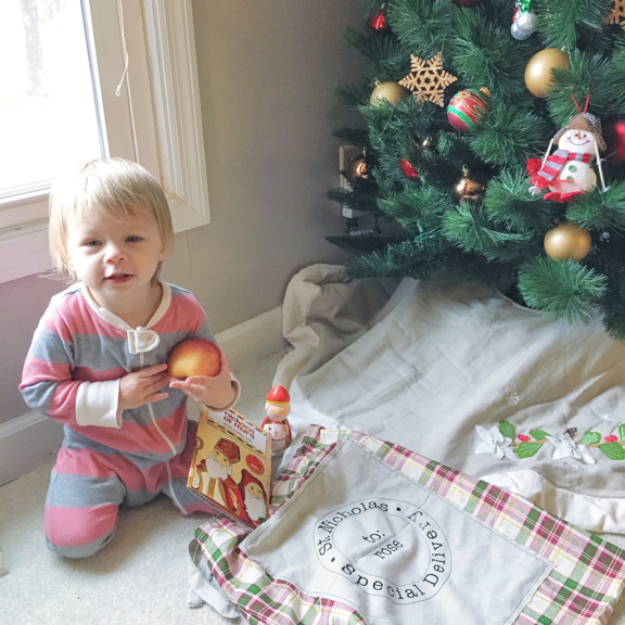 Rose sitting with her gifts by the Christmas tree