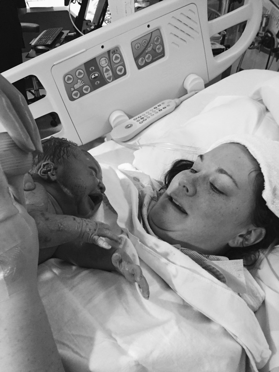 Becky in a hospital bed holding Kolbe for the first time