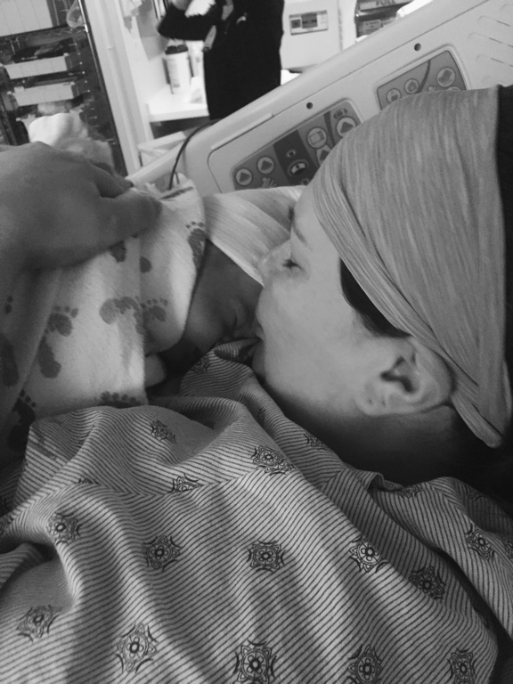 Becky in a hospital bed holding Rose for the first time