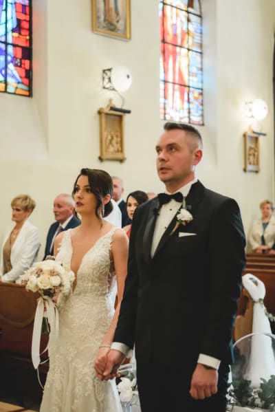 Para młoda stoi w nawie kościoła podczas liturgii