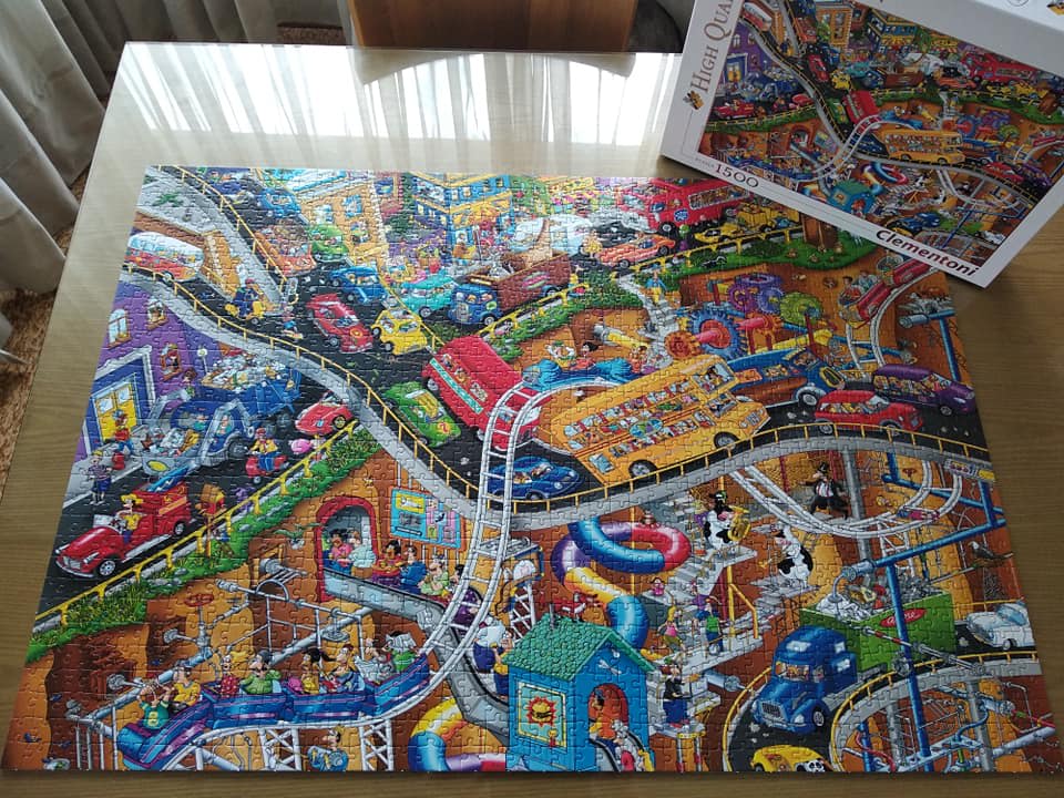 A chaotic, high-angle illustration of a multi-level city with winding roads, colorful vehicles, and cartoon characters.