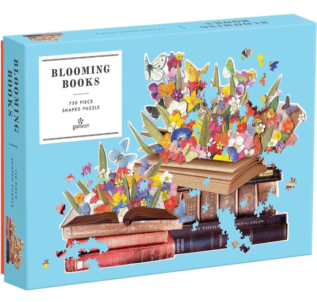 A stack of antique books bursting with vibrant colorful wildflowers and butterflies against a light blue background.