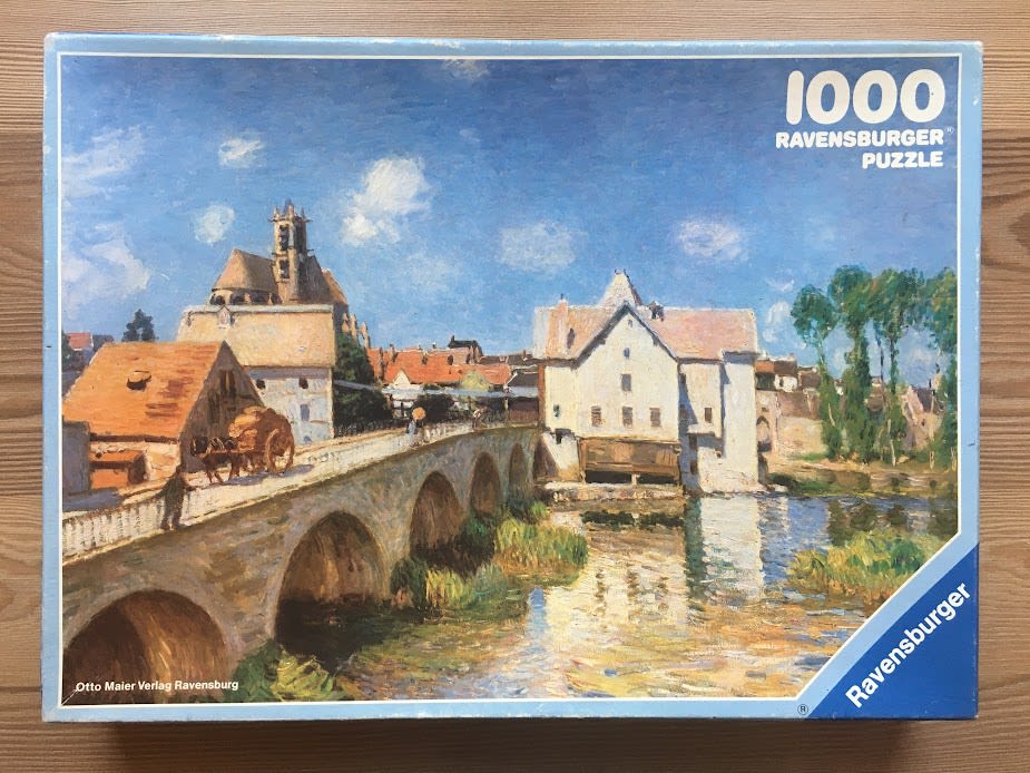 Impressionist painting of a stone bridge over a river leading to a quaint European village with a church tower.