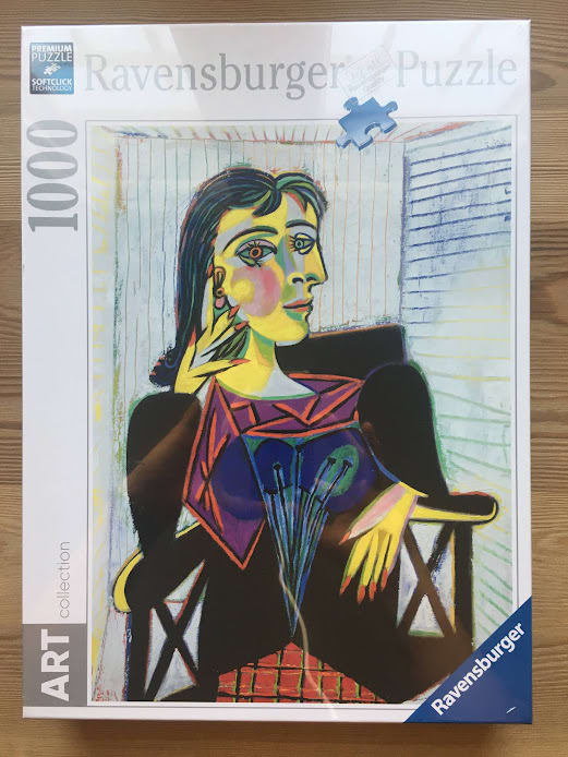A cubist painting of a woman sitting in a chair, rendered in bold lines and vibrant colors in the style of Pablo Picasso.
