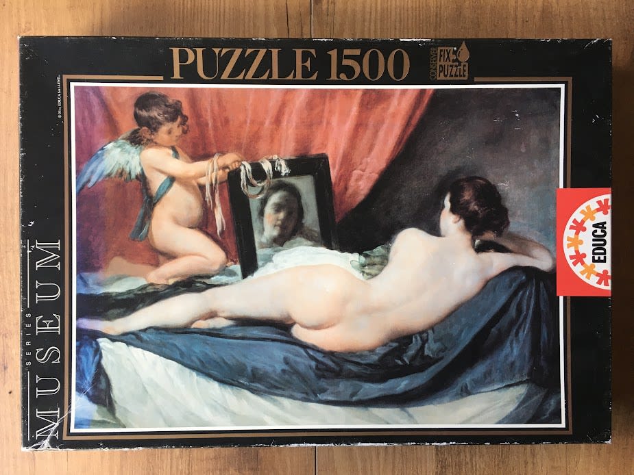 Oil painting of a reclining nude woman gazing into a mirror held by a winged cupid.