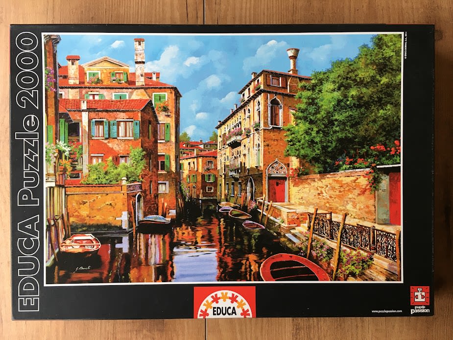 An oil painting of a sunlit canal in Venice, Italy, flanked by weathered orange and terracotta buildings.