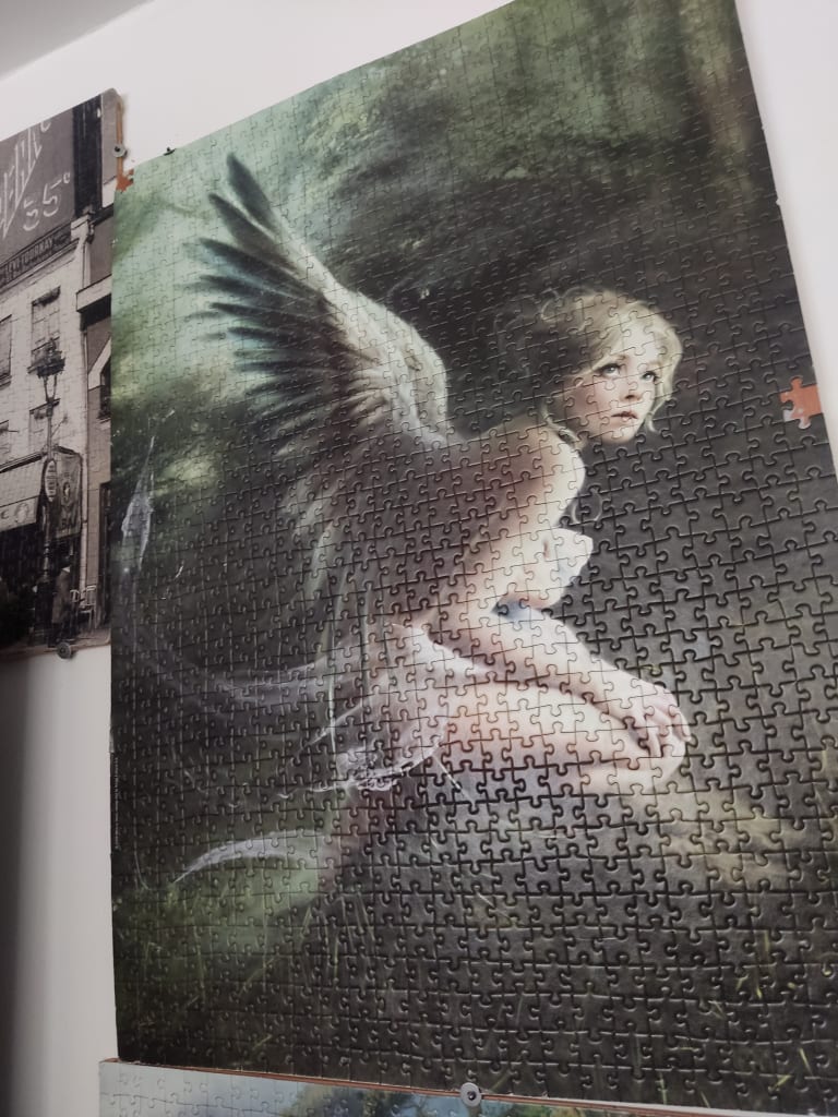 A digital painting of a winged angel with blonde hair kneeling in a dark, forest-like environment.