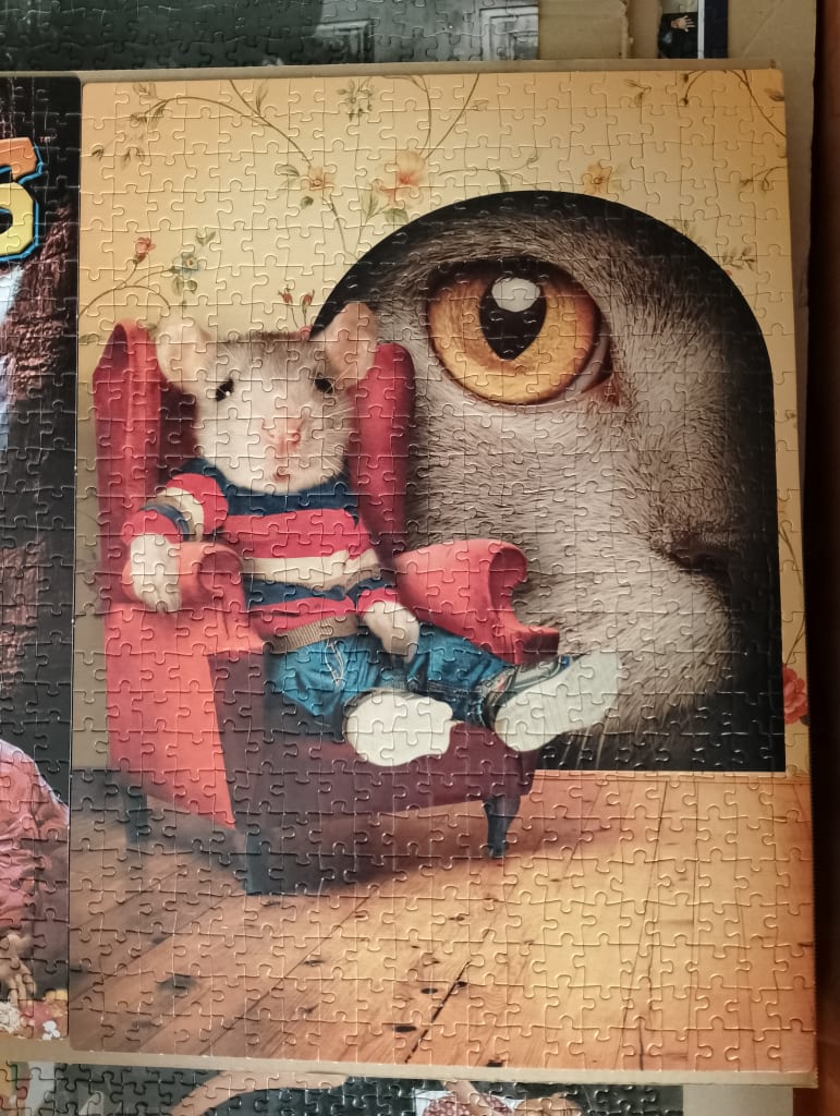 A mouse in a striped shirt sitting in a red chair in front of a giant cat eye