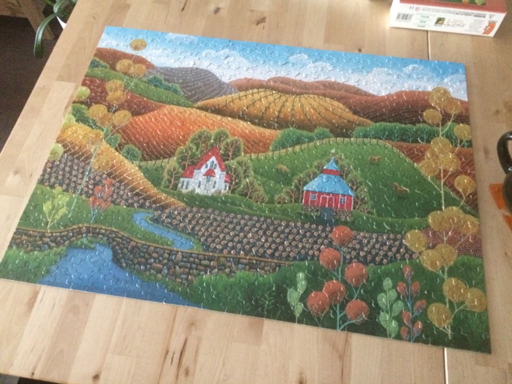 Folk art style painting of a rolling countryside landscape with two small houses, a stream, and autumnal trees.