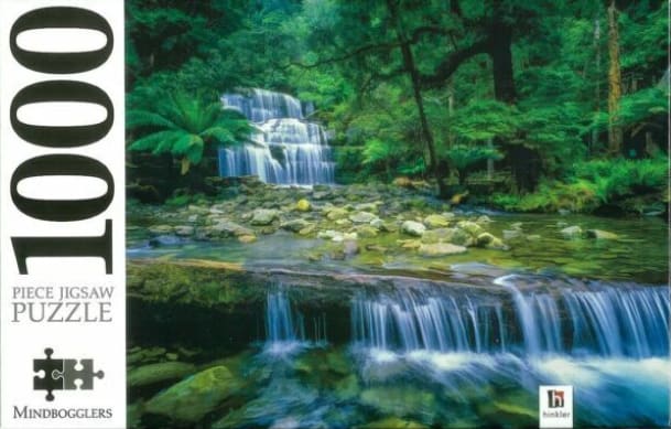 A lush, multi-tiered waterfall cascading down through a dense, vibrant green rainforest.