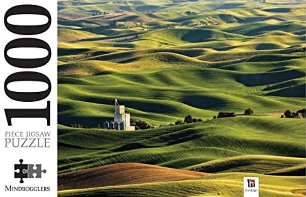 Rolling green hills of the Palouse landscape with a small grain silo in the distance