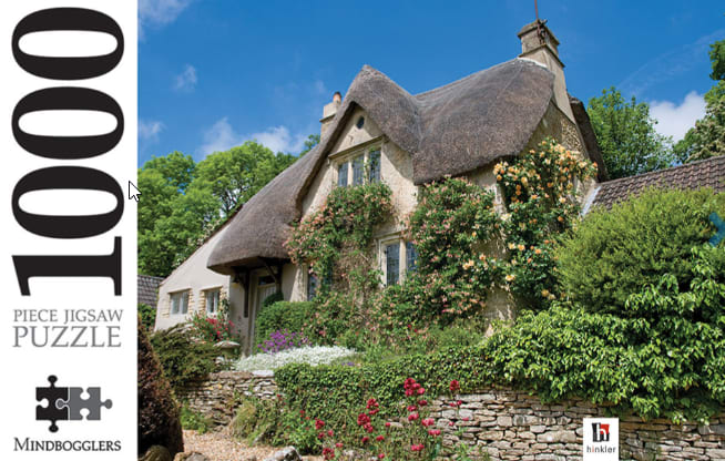 A charming English cottage with a thatched roof, surrounded by a stone wall and blooming flowers in a garden.