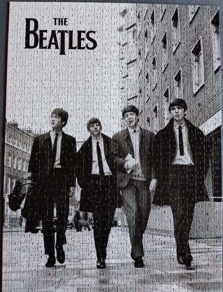 The Beatles walking down a London street in a black and white photograph