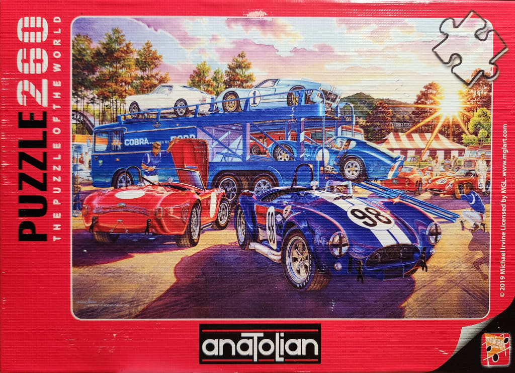 Illustration of vintage Cobra race cars being unloaded from a transport truck at a sunny race track.