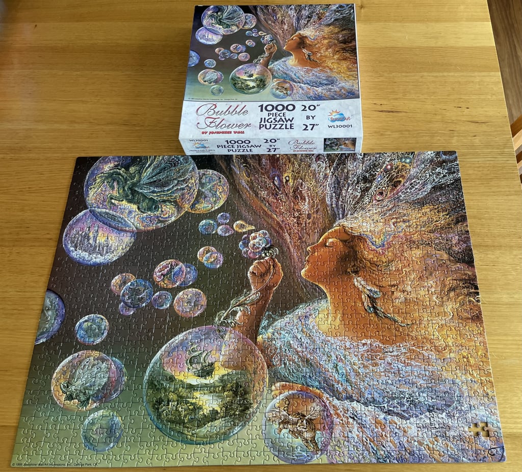 Fantasy illustration of a woman blowing bubbles containing miniature scenes, by Josephine Wall.
