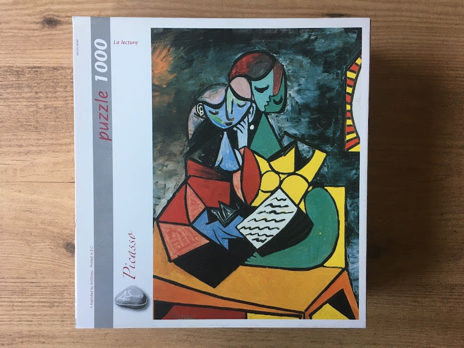 Painting titled La lecture by Picasso showing two figures reading together in cubist style.